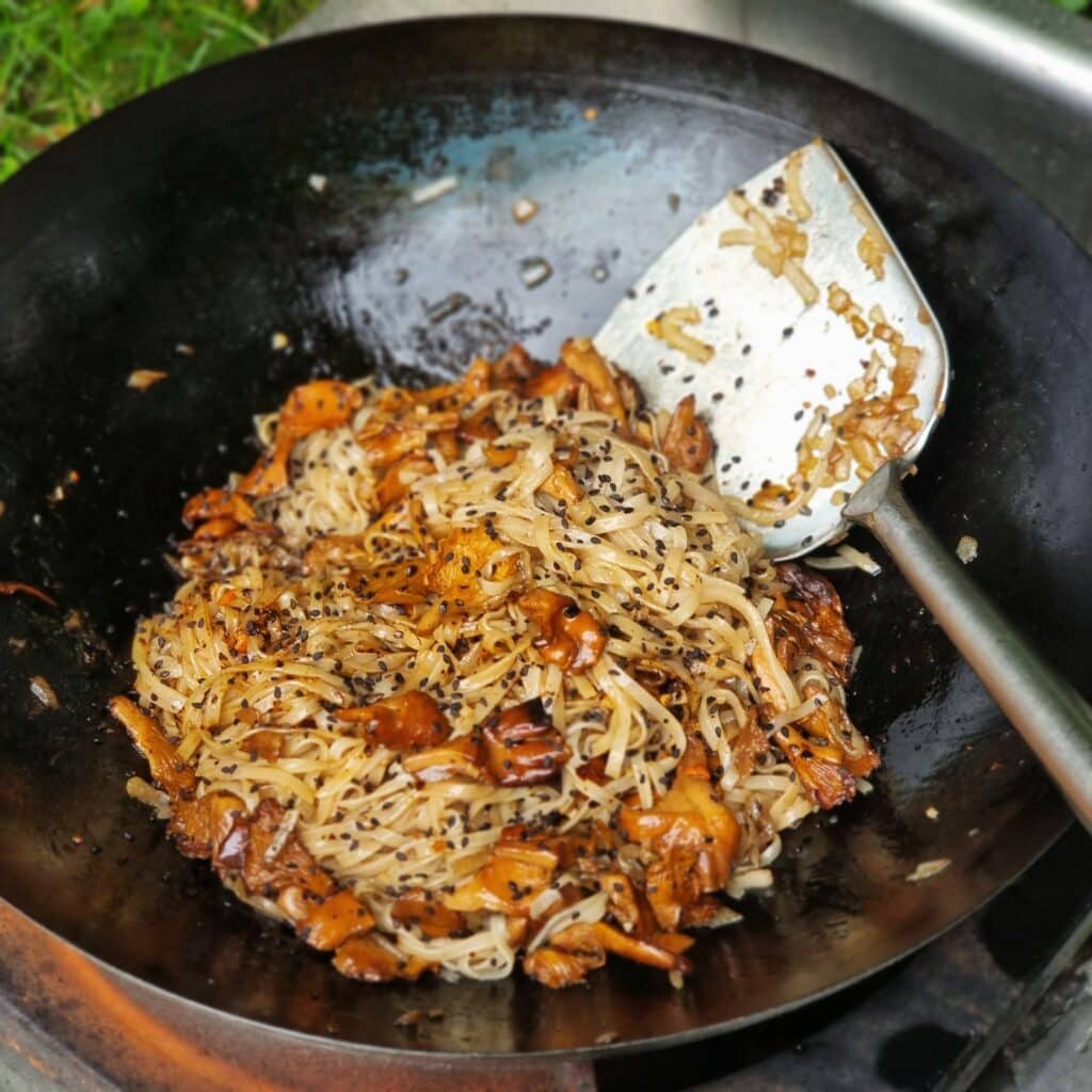 Chanterelles from the wok with garlic butter rice noodles